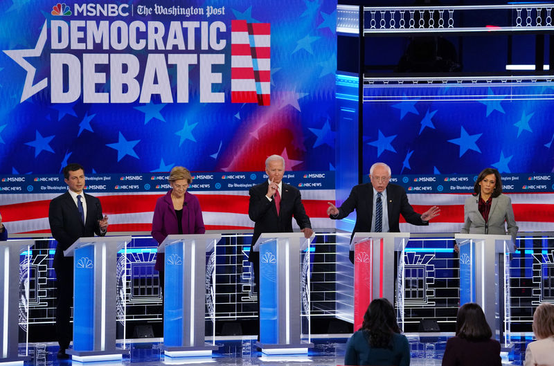 © Reuters. Democratic U.S. presidential candidates Buttigieg, Warren, Biden and Harris listen as Senator Bernie Sanders speaks during their fifth 2020 campaign debate at the Tyler Perry Studios in Atlanta