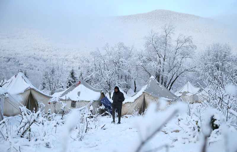 © Reuters. A migrant walks at a snow covered makeshift forest camp near Croatian border in Bihac