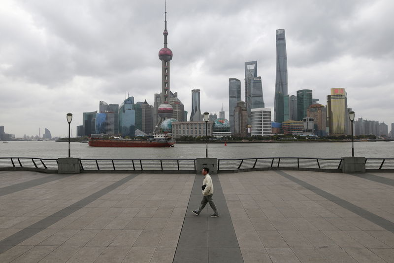 © Reuters. A man walks on the bund in front of the financial district of Pudong in Shanghai