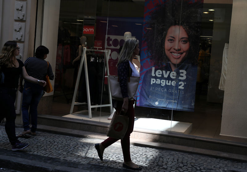 © Reuters. Pessoas passam em frente a loja no Rio de Janeiro