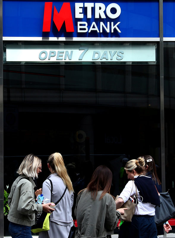 © Reuters. FILE PHOTO: People walk past a Metro Bank in London
