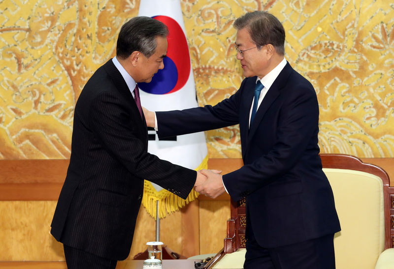 © Reuters. Chinese Foreign Minister Wang Yi is greeted by South Korean President Moon Jae-in during their meeting at the Presidential Blue House in Seoul