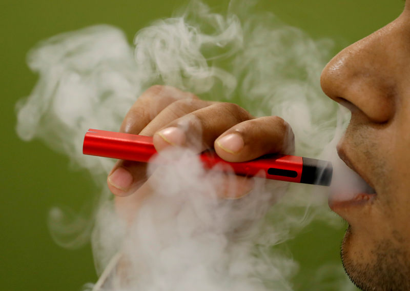 © Reuters. A man uses a vape device in this illustration picture