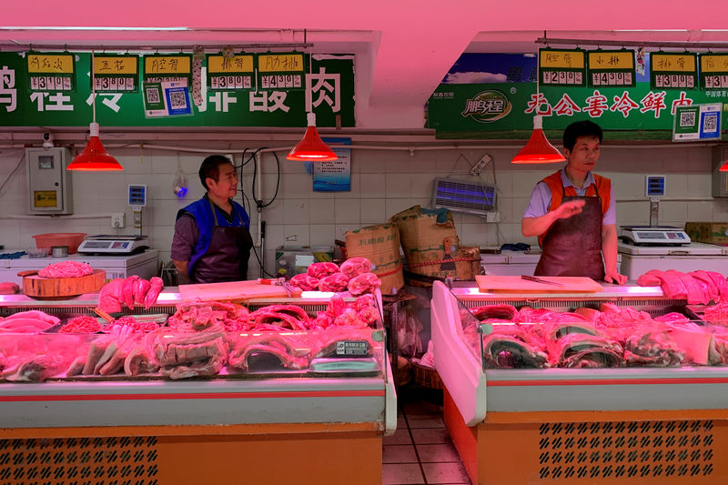 © Reuters. FILE PHOTO: Pork vendors at a market in Beijing