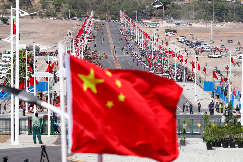© Reuters. Una bandera nacional china ondea frente a una carretera principal construida por los chinos, antes de una ceremonia de bienvenida para el presidente de China, Xi Jinping, antes de la Cumbre APEC en Port Moresby