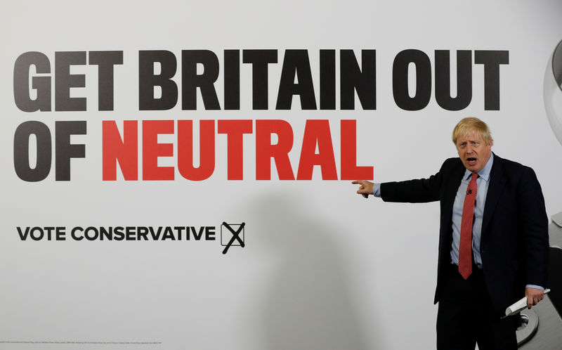 © Reuters. El primer ministro británico, Boris Johnson, muestra un cartel de campaña en Detling, Reino Unido.