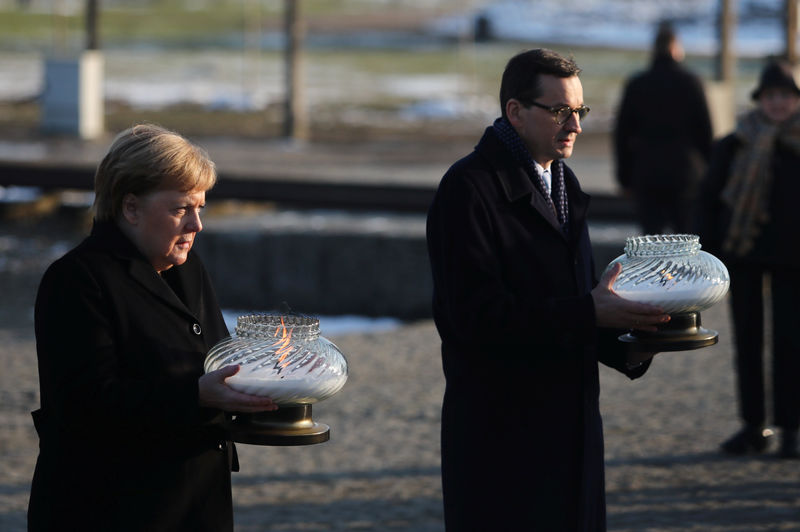 © Reuters. La canciller alemana, Angela Merkel, y el primer ministro polaco, Mateusz Morawiecki en su visita al memorial del Holocausto Auschwitz-Birkenau, cerca de Oswiecim, Polonia