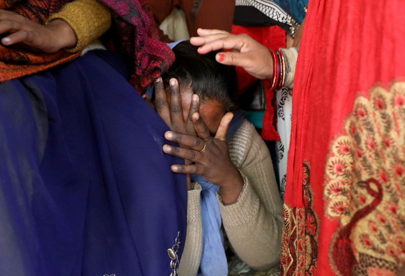 © Reuters. Un pariente de la víctima de violación de 23 años de edad, que murió en un hospital de Nueva Delhi el viernes después de haber sido quemada por una banda de hombres, entre los que se encontraban sus presuntos violadores, es consolada mientras llora l