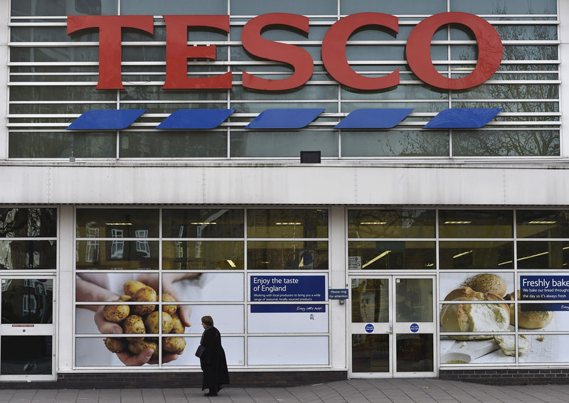 © Reuters. Woman walks past a Tesco supermarket in central London