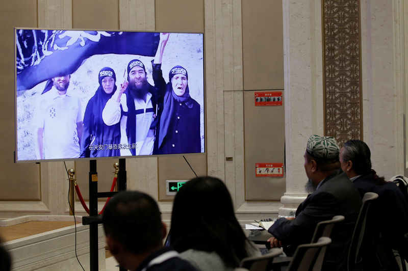 © Reuters. An image of what has been described as scenes of past violence is displayed in excerpts from a documentary "Fighting Terrorism in Xinjiang" at a news conference in Beijing