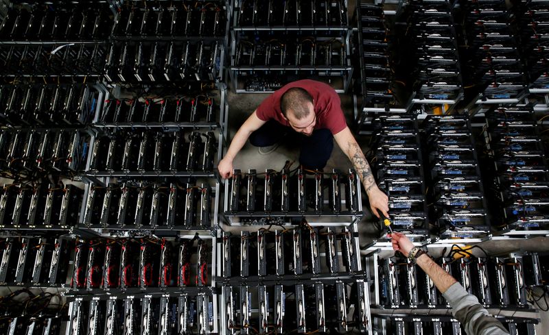© Reuters. FILE PHOTO: Employees work on bitcoin mining computers at Bitminer Factory in Florence