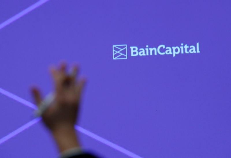 © Reuters. FILE PHOTO: A reporter raises his hand to ask a question during a news conference by Bain Capital LP Managing Director Sugimoto in Tokyo
