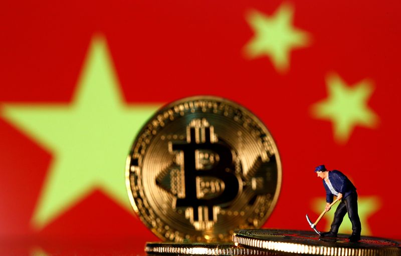 © Reuters. FILE PHOTO:  Picture illustration of a small toy figurine and representations of the Bitcoin virtual currency displayed in front of an image of China's flag