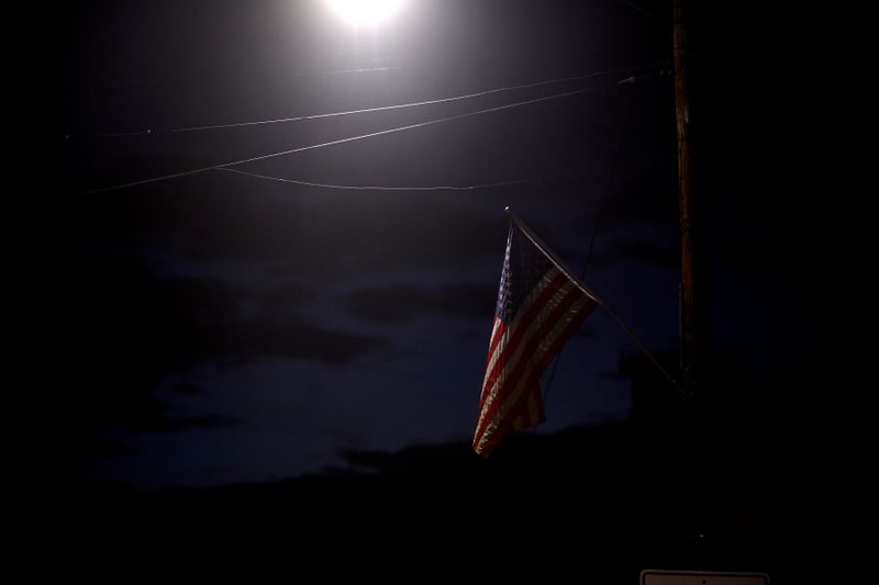 © Reuters. Una luz de la calle ilumina una bandera de los Estados Unidos el día de las elecciones para las elecciones estatales y locales en Kulpmont