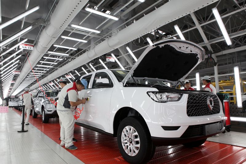 © Reuters. FILE PHOTO: Workers inspect vehicles at a workshop of a production base of Great Wall Motors in Yongchuan, Chongqing