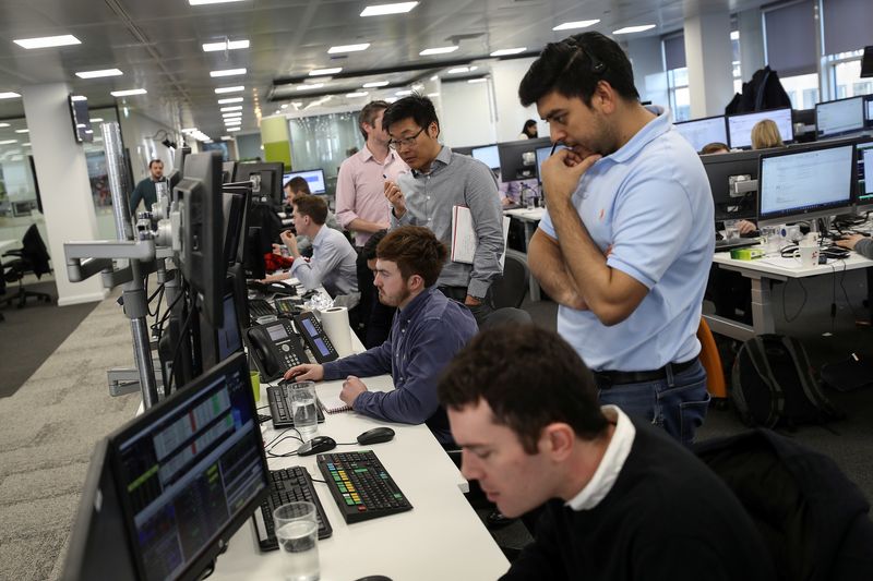 © Reuters. Traders looks at financial information on computer screens on the IG Index trading floor