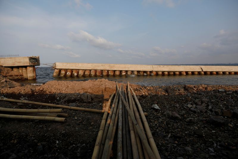 © Reuters. Crumbled sea wall is pictured in an area affected by land subsidence and rising sea levels, in northern coast of Jakarta