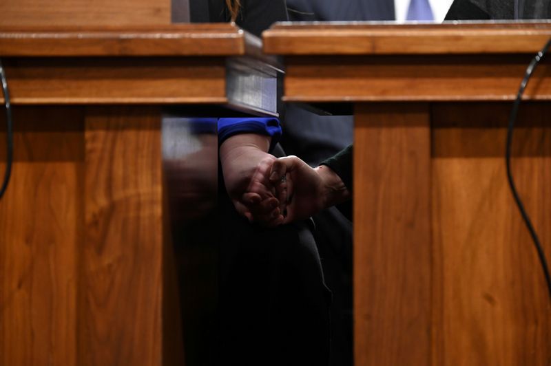 © Reuters. FILE PHOTO: Military family members hold hands before testifying before Senate Armed Services subcommittees on the Military Housing Privatization Initiative in Washington