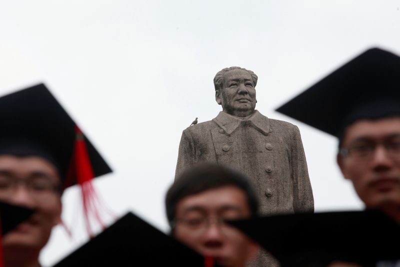 © Reuters. FILE PHOTO: Graduates pose for picture in front of statue of late Chinese leader Mao after graduation ceremony at Fudan University in Shanghai