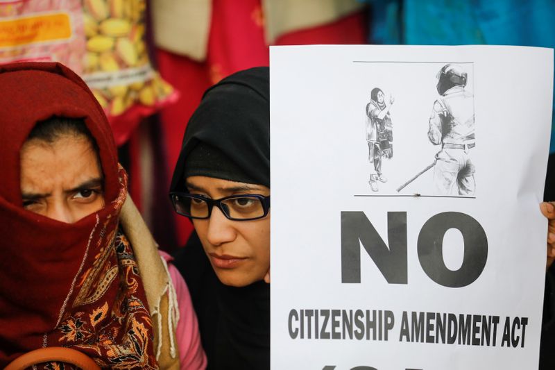 © Reuters. طالبات محجبات يتصدين للشرطة الهندية في إطار احتجاجات على قانون الجنسية الجديد