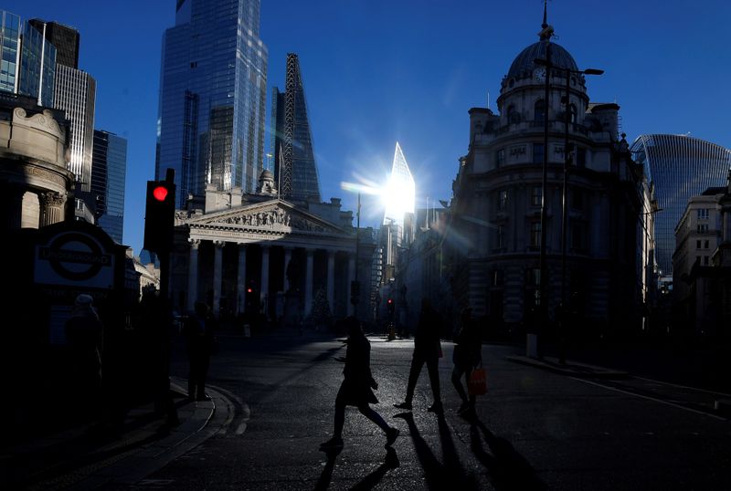 © Reuters. FILE PHOTO: Workers cross the road in the City of London, near the Royal Exchange and Bank of England