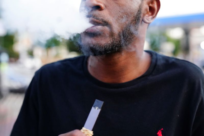 © Reuters. A man uses a Juul vaporizer in Atlanta