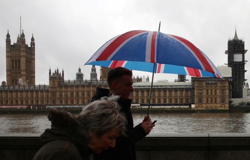 © Reuters. Pessoas caminham pela Ponte Westminster em dia de chuva em Londres