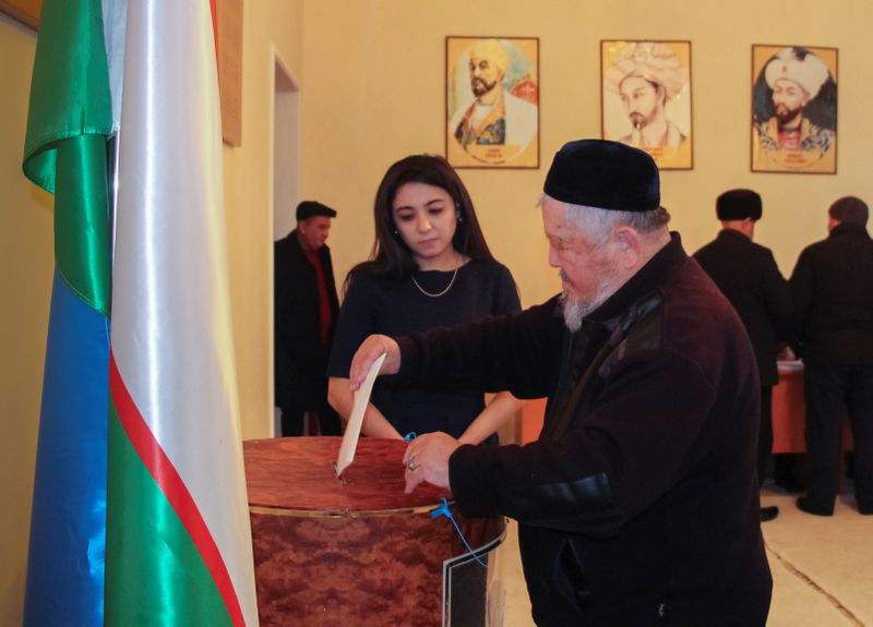 © Reuters. A man casts his ballot during parliamentary election in Tashkent,