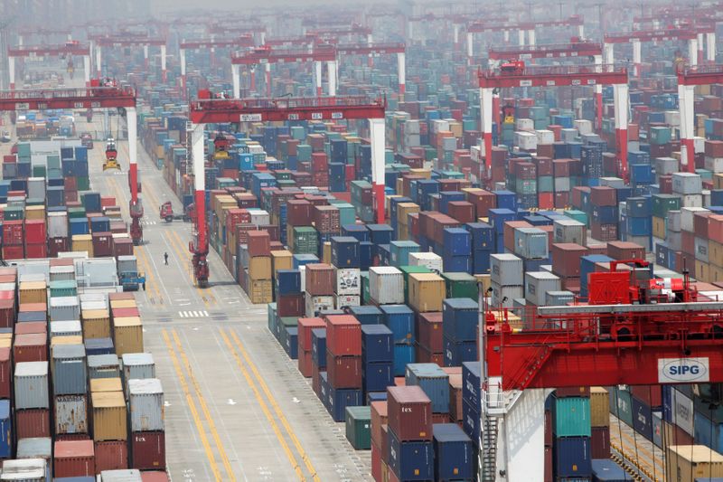 © Reuters. FILE PHOTO: A man walks in a shipping container area at Yangshan Port of Shanghai