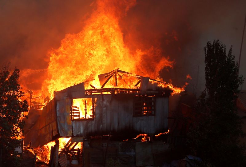© Reuters. A house burns following the spread of wildfires in Valparaiso