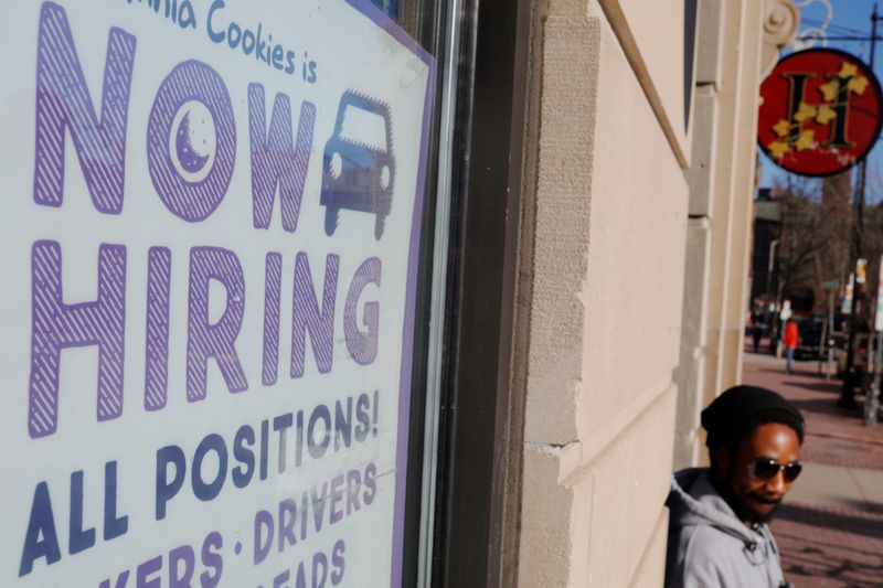 © Reuters. USA "Now Hiring" sign sits in the window of Insomnia Cookies in Cambridge