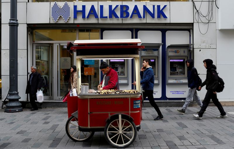 © Reuters. A street vendor sells roasted chestnuts in front of a branch of Halkbank in central Istanbul