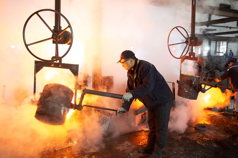 © Reuters. Worker pours molten iron into a mould at a mill manufacturing marine engine components in Huaian, Jiangsu