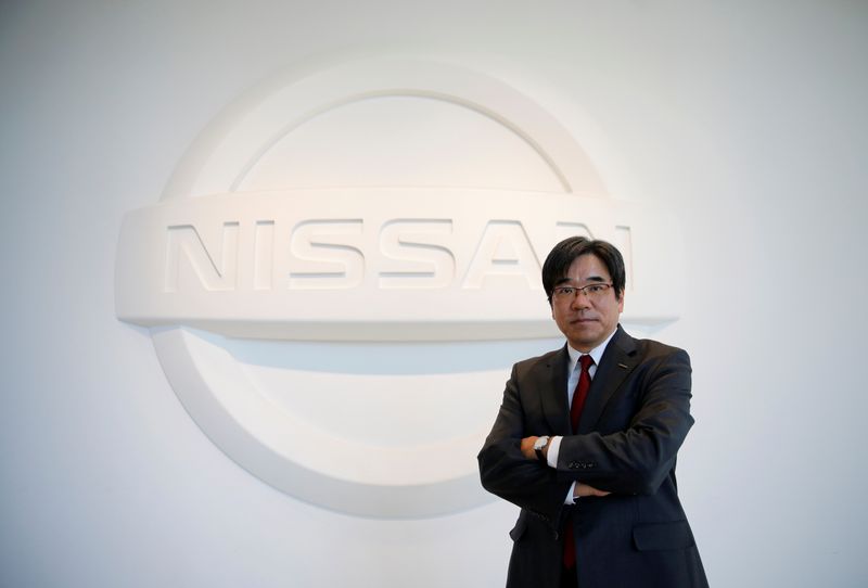 © Reuters. Nissan Executive Vice President Sakamoto poses with the carmaker's logo in the showroom at the carmaker's headquarters in Yokohama