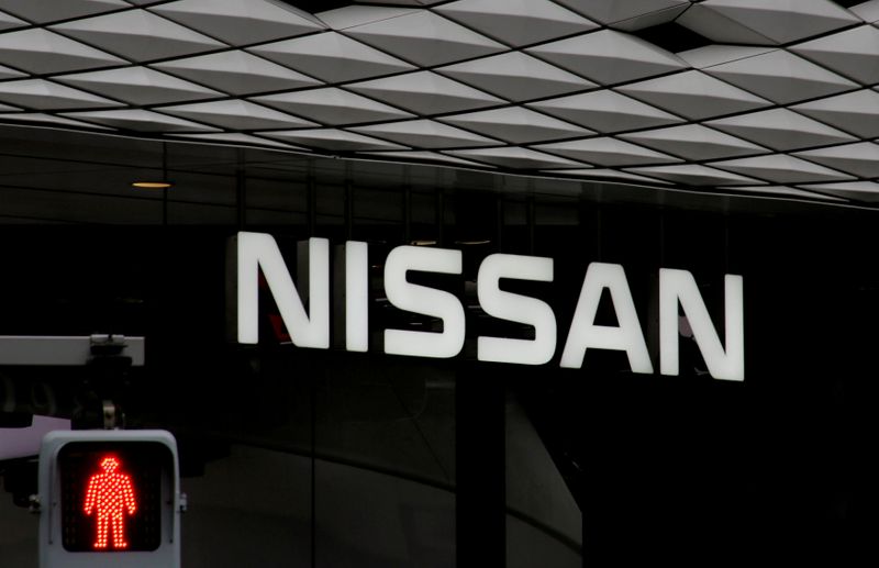 © Reuters. FILE PHOTO: The logo of Nissan Motor Co. is seen at its show room behind a traffic sign in Tokyo