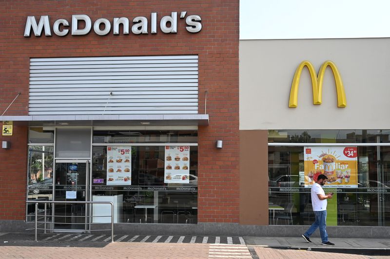 © Reuters. A person walks next to a closed McDonald's restaurant, one of all 29 locations that were closed following the deaths of two teenaged employees, in Lima