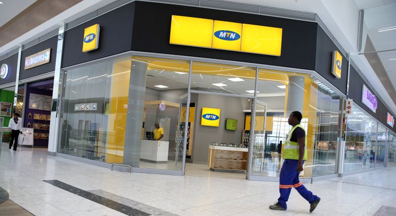 © Reuters. FILE PHOTO: A worker walks past an outlet of South Africa's MTN Group in Johannesburg, South Africa