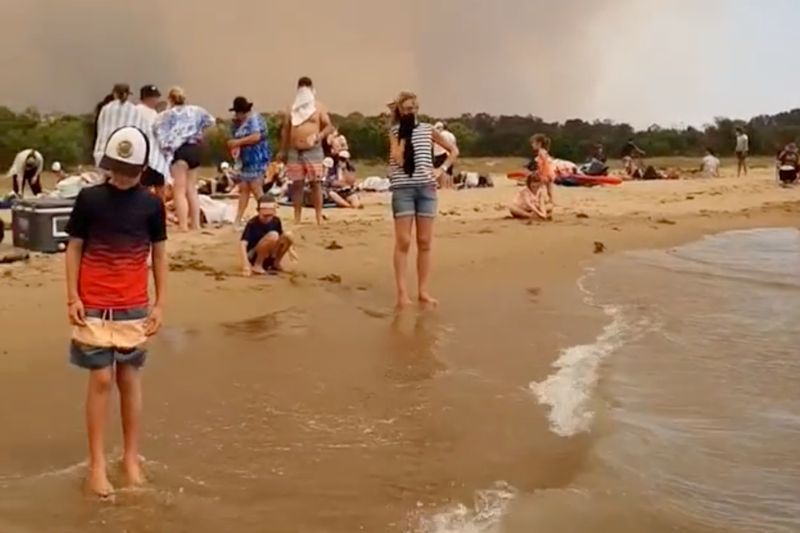 © Reuters. People at the beach evacuate from the bushfires at Batemans Bay