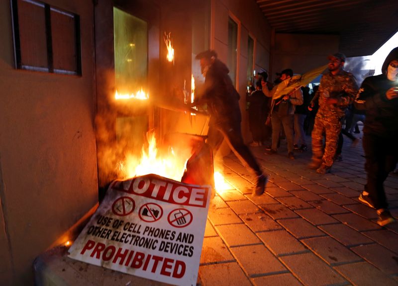 © Reuters. Protesters and militia fighters set fire to a reception room of the U.S. Embassy, during a protest to condemn air strikes on bases belonging to Hashd al-Shaabi, in Baghdad