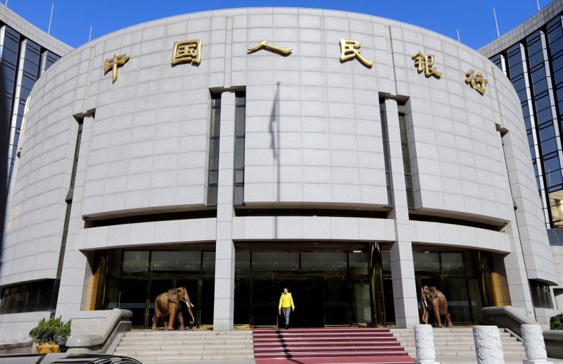 © Reuters. FILE PHOTO: A woman walks out of the headquarters of PBOC in Beijing