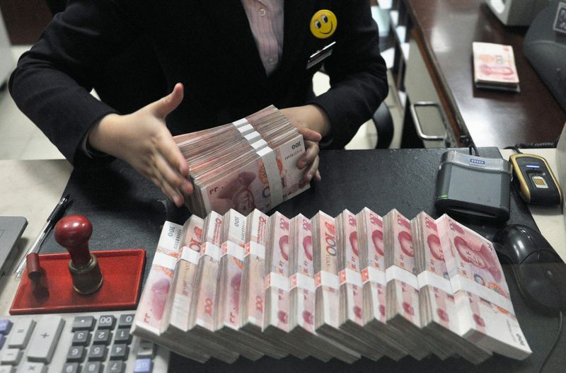 © Reuters. A clerk arranges bundles of 100 Chinese yuan banknotes at a branch of China Merchants Bank in Hefei