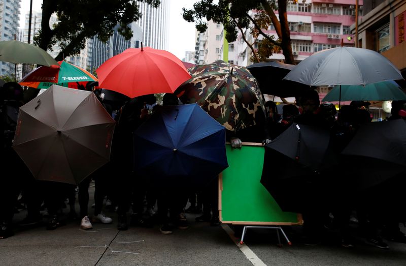 © Reuters. Manifestantes se guarecen detrás de paraguas en marcha de Año Nuevo, Hong Kong