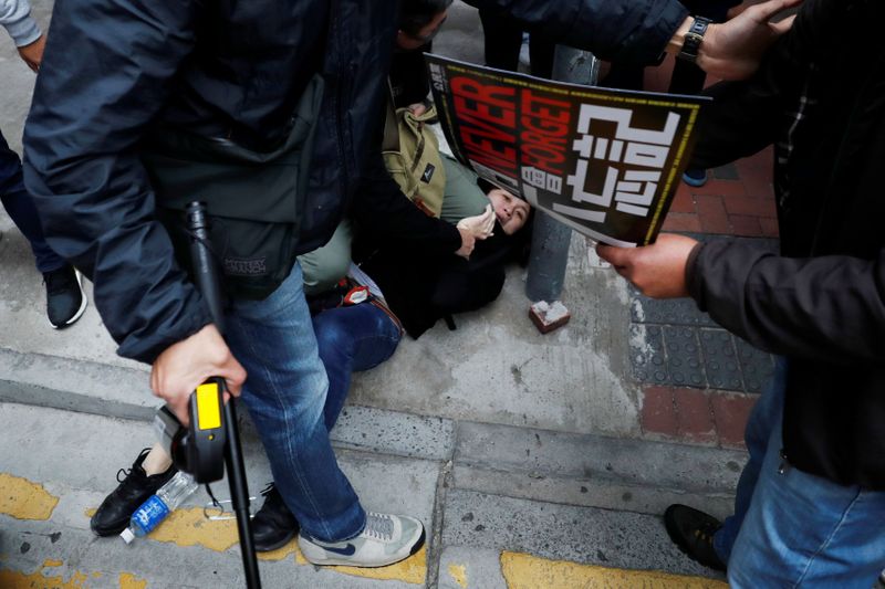 © Reuters. A woman is detained by plain-cloth police officers during an anti-government demonstration on New Year's Day, to call for better governance and democratic reforms in Hong Kong