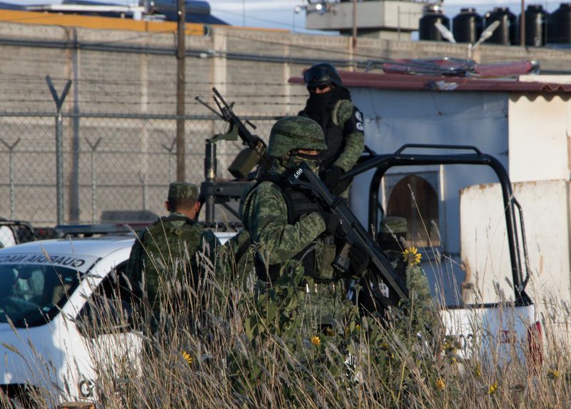 © Reuters. Members of the Mexican National Guard stand atop a vehicle as they keep watch outside the prison after sixteen inmates were killed and five were wounded in a prison fight at the Regional Center for Social Reintegration in the town of Cieneguillas