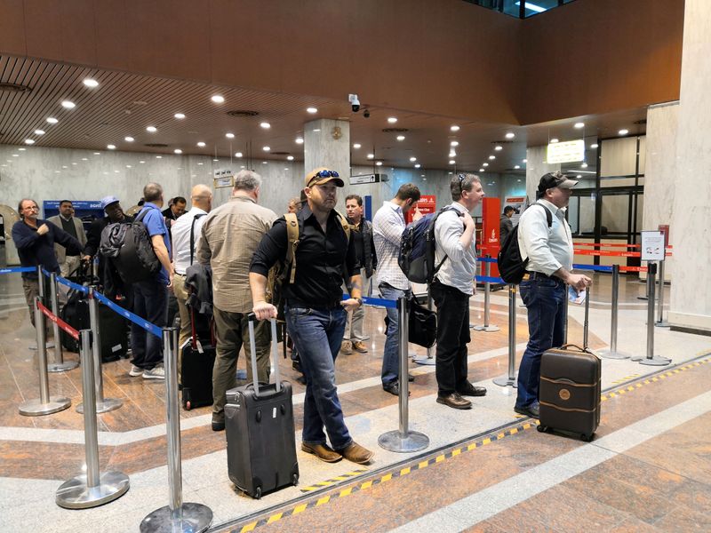 © Reuters. Empleados extranjeros de compañías petroleras dejan Irak en el aeropuerto de Basora