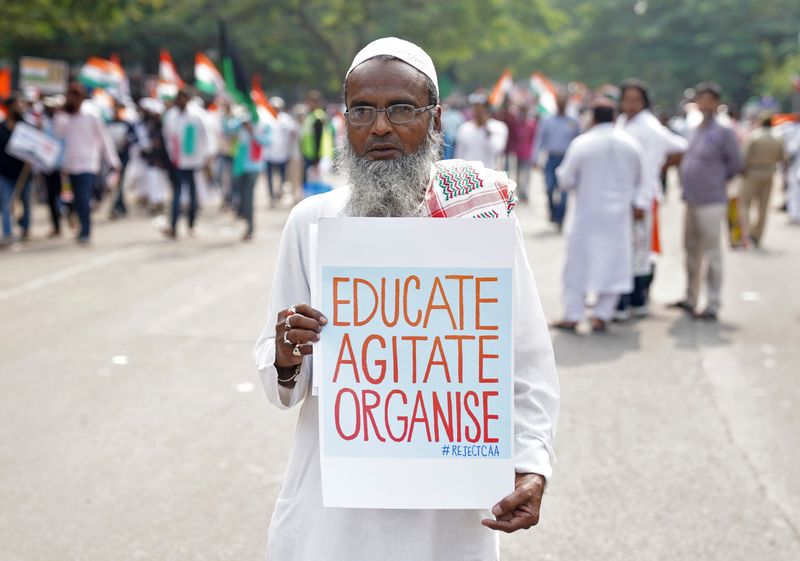 © Reuters. A demonstrator displays a placard as he attends a protest rally against a new citizenship law, in Hyderabad