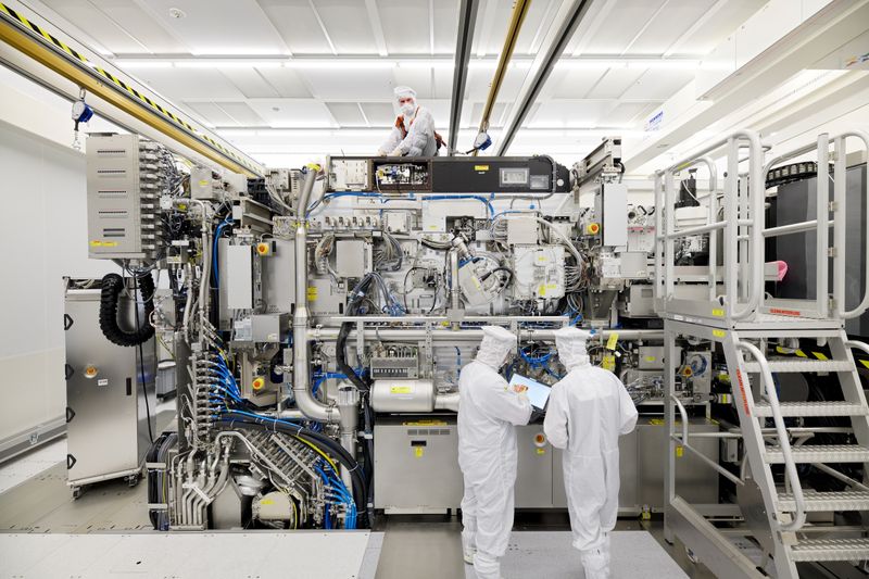 © Reuters. Employees are seen working on the final assembly of ASML's TWINSCAN NXE:3400B semiconductor lithography tool with its panels removed, in Veldhoven