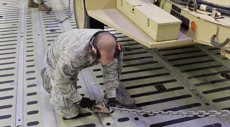 © Reuters. A soldier adjusts a military vehicle that is loaded onto aircraft by the 1st Brigade Combat Team, 82nd Airborne Division, in Fort Bragg