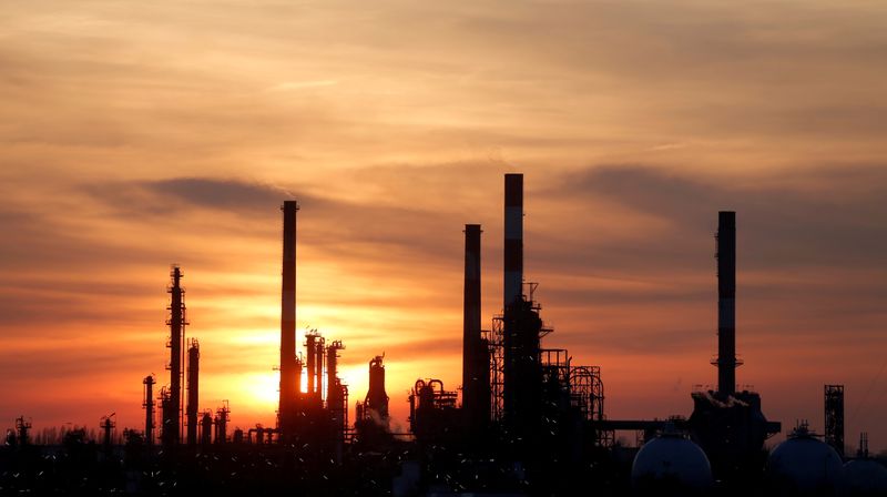 © Reuters. FILE PHOTO: The sun sets behind the chimneys of the Total Grandpuits oil refinery southeast of Paris