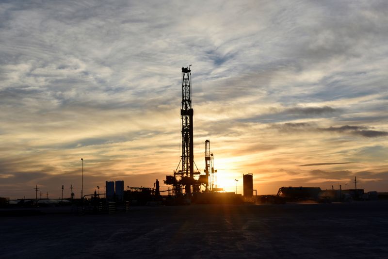 © Reuters. Drilling rigs operate at sunset in Midland